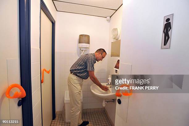 La grippe fait exploser les ventes d'une poignée de porte +anticontamination+" - A man washs his hands in toilets kiped out by the first ergonomic...