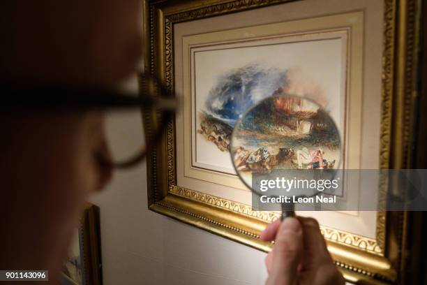 Dealer poses with "The Field of Waterloo from Hougoumont" by Turner at the Mayfair Antiques and Fine Arts Fair on January 4, 2018 in London, England....