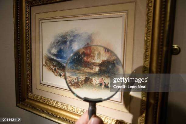 Dealer poses with "The Field of Waterloo from Hougoumont" by Turner at the Mayfair Antiques and Fine Arts Fair on January 4, 2018 in London, England....