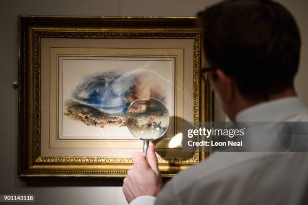 Dealer poses with "The Field of Waterloo from Hougoumont" by Turner at the Mayfair Antiques and Fine Arts Fair on January 4, 2018 in London, England....