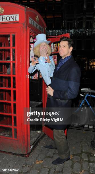 Jim Carrey poses with his puppet Harry Dunne, from Dumb and Dumber, inside a London telephone box, covered in call girl advertising, after dining at...