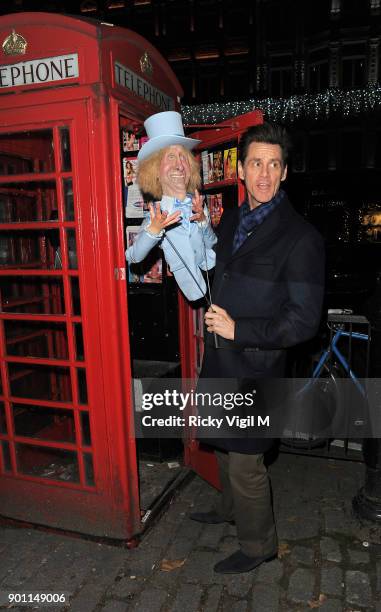 Jim Carrey poses with his puppet Harry Dunne, from Dumb and Dumber, inside a London telephone box, covered in call girl advertising, after dining at...