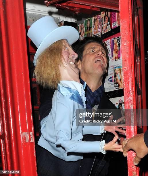 Jim Carrey poses with his puppet Harry Dunne, from Dumb and Dumber, inside a London telephone box, covered in call girl advertising, after dining at...