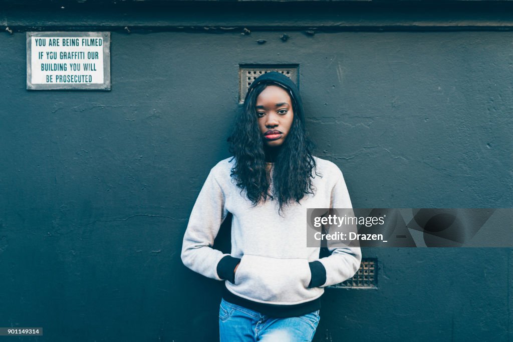 Afrikanische Frau stand in der Nähe der Wand mit Warnschild