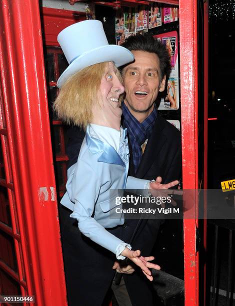 Jim Carrey poses with his puppet Harry Dunne, from Dumb and Dumber, inside a London telephone box, covered in call girl advertising, after dining at...