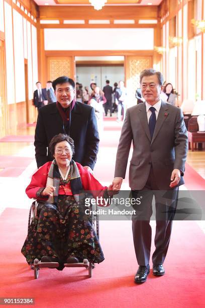In this handout photo released by the South Korean Presidential Blue House, South Korean President Moon Jae-in meets 'comfort women', former South...