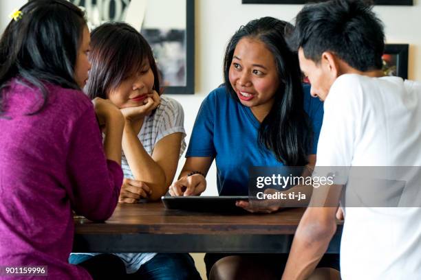 amis avec une tablette numérique - indonesian ethnicity photos et images de collection