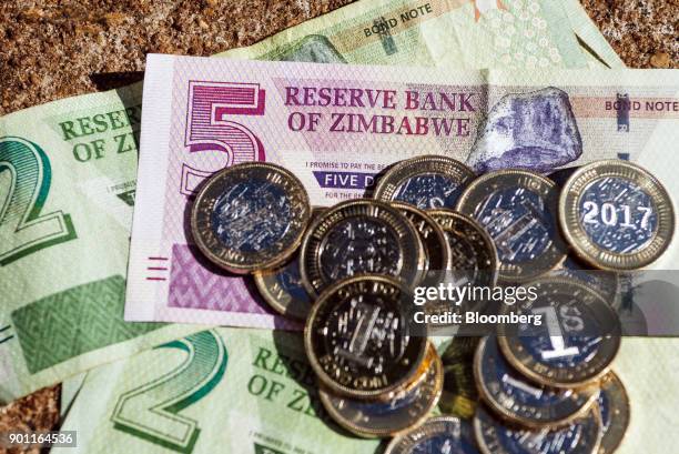 Zimbabwean one dollar bond coins, nicknamed zollars, sit on top of five and two dollar bond banknotes in an arranged photo in Harare, Zimbabwe, on...