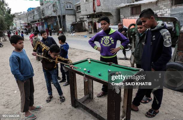 Palestinian boys play pool in the Rafah refugee camp in the southern Gaza Strip on January 4, 2018.