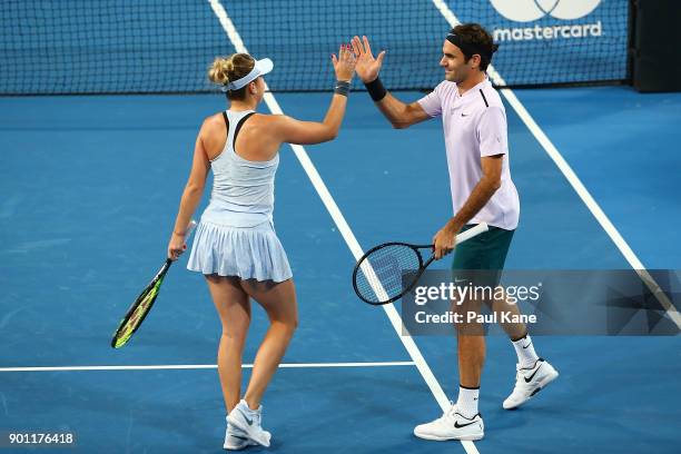 Belinda Bencic and Roger Federer of Switzerland celebrate winning a set in the mixed doubles match against CoCo Vandeweghe and Jack Sock of the...