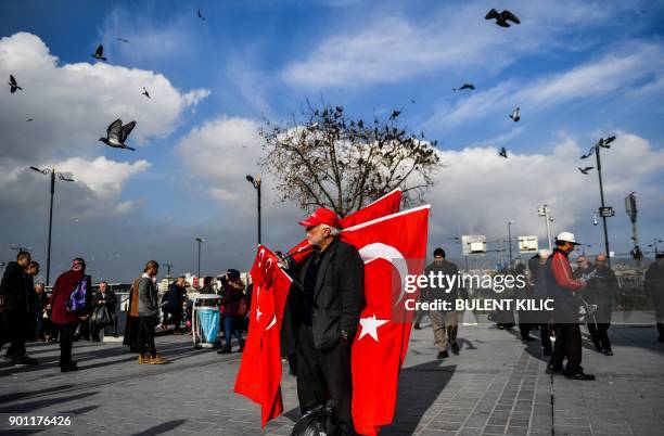Vendor sells Turkish national flags in Eminonu Square on the European side of Istanbul on January 4, 2018. / AFP PHOTO / BULENT KILIC
