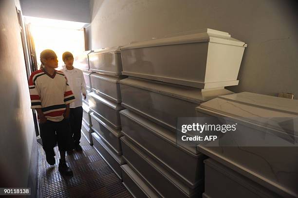 People look August 27, 2009 in Huamanga, Peru, at coffins containing the remains of victims of a massacre occured in 1984 in Putis, Ayacucho, 600 km...
