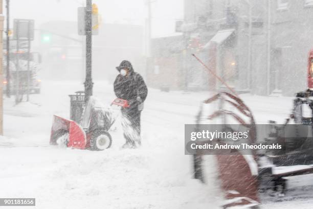 People plow snow as a blizzard hits the Northeastern part of the United States January 4, 2018 in Patchogue, New York.