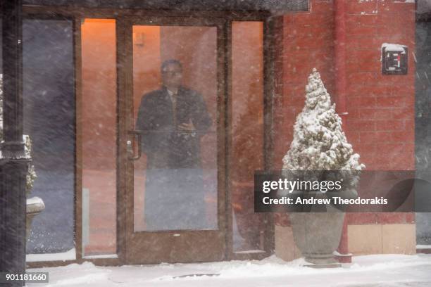 Man watches the snow as a blizzard hits the Northeastern part of the United States January 4, 2018 in Patchogue, New York.