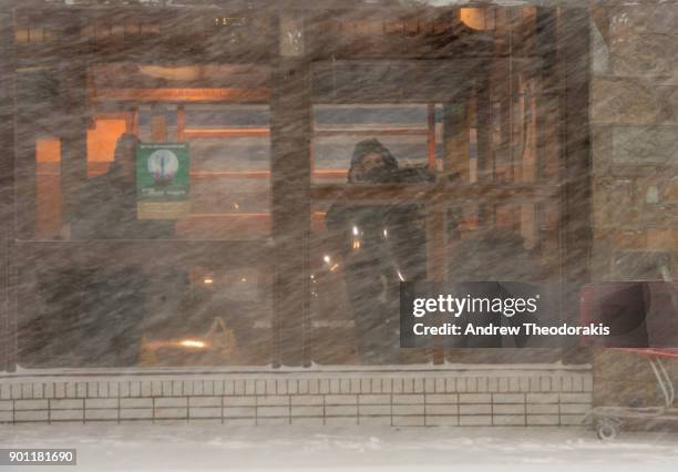 People wait at the Long Island Rail Road station as a blizzard hits the Northeastern part of the United States January 4, 2018 in Patchogue, New York.