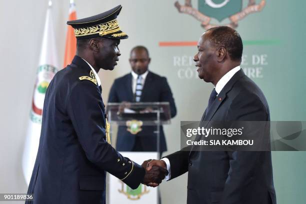 Ivorian President Alassane Ouattara shakes hands with Chief of staff of the Armed forces of Ivory Coast general Sekou Toure , after a New Year wishes...