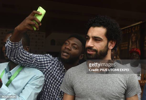Fan takes a selfie with African Player of the Year Award nominee and Liverpool's Egyptian striker Mohamed Salah before a media briefing on the...
