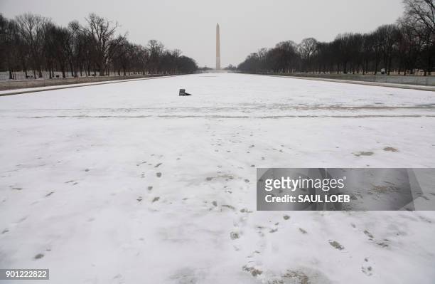 The Lincoln Memorial Reflecting Pool on the National Mall is frozen during a snow storm in Washington, DC, January 4, 2018. A giant winter "bomb...