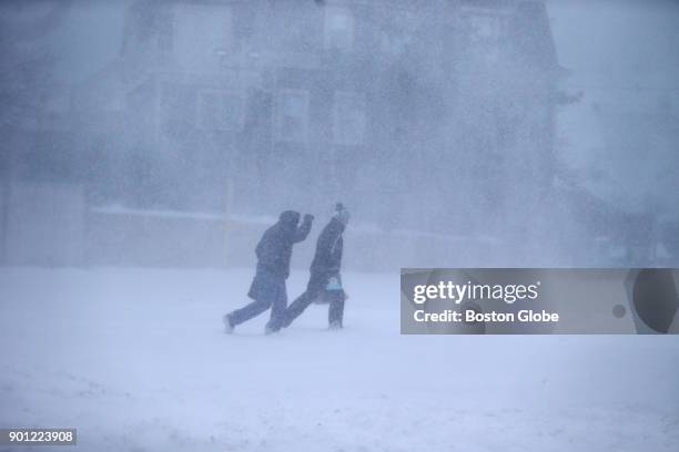 Two people brave snow and high winds during a winter storm in Hingham, MA on Jan. 4, 2018.