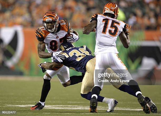 Wide receiver Andre Caldwell of the Cincinnati Bengals attempts to break the tackle of Quincy Butler of the St. Louis Rams during the preseason game...