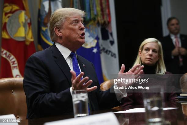President Donald Trump speaks as Homeland Security Secretary Kirstjen Nielsen listens during a meeting in the Roosevelt Room of the White House...