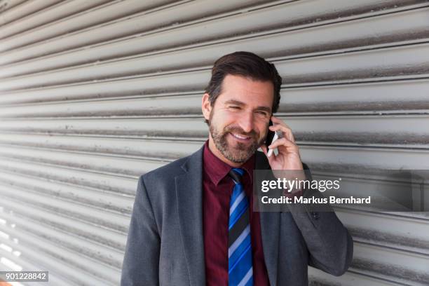 businessman talking on his cellphone - dark haired man gray shirt with wine stock pictures, royalty-free photos & images