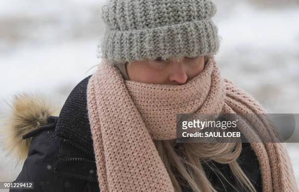 Woman covers her face as she visits the Lincoln Memorial on the National Mall in Washington, DC, January 4, 2018. A giant winter "bomb cyclone"...