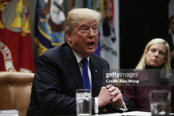 President Donald Trump speaks as Homeland Security Secretary Kirstjen Nielsen listens during a meeting in the Roosevelt Room of the White House...