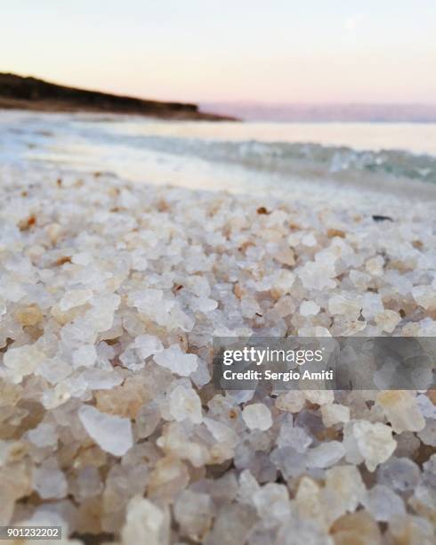 close up of grains of salt on the jordanian shore of the dead sea at sunrise - salt mineral stock pictures, royalty-free photos & images