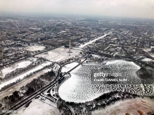 This aerial photograph shows snow in Washington,DC with the Washington Memorial Monument in the distance on January 4, 2018. - A giant winter "bomb...