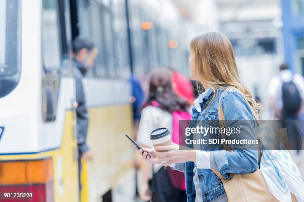 half volwassen vrouwtje zich voorbereidt op de raad van bestuur commuter trein - crowded train station smartphone stockfoto's en -beelden