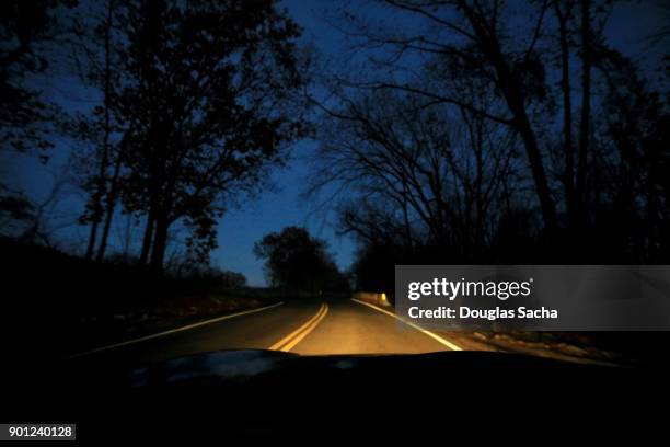 first person view of a spooky road at night - dark background light stock-fotos und bilder
