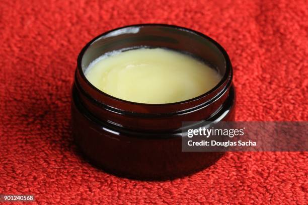 container of moisturizing cream on a red background - spiky hair stock pictures, royalty-free photos & images