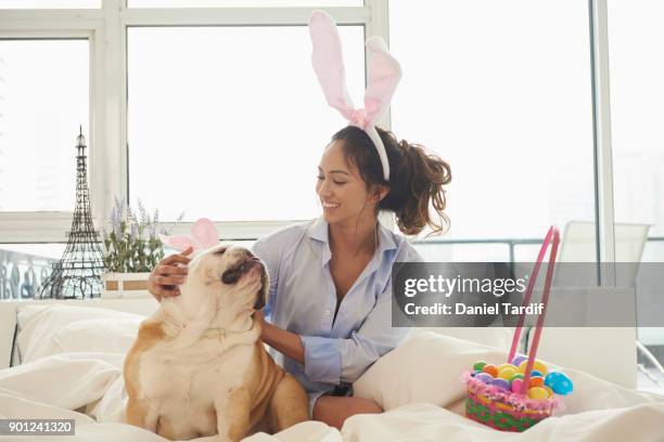 young woman on bed with dog - dog easter imagens e fotografias de stock