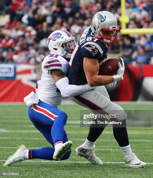 Jordan Poyer of the Buffalo Bills tackles Rob Gronkowski of the New England Patriots during the game at Gillette Stadium on December 24, 2017 in...