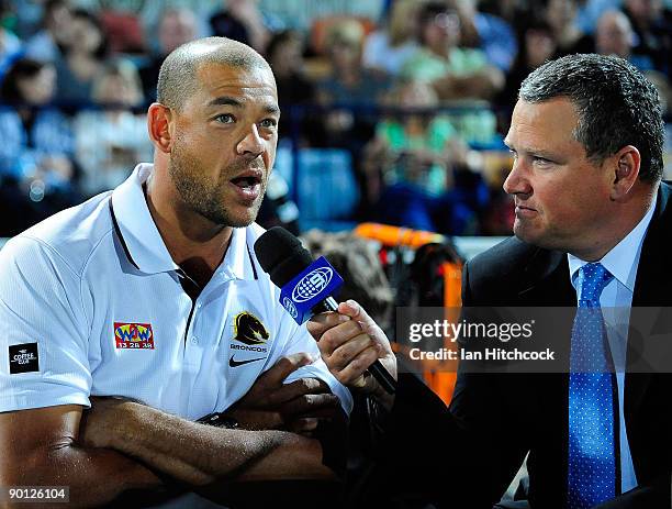 Former Australian cricketer Andrew Symonds talks to Channel 9 commentator Tim Gilbert during the round 25 NRL match between the North Queensland...