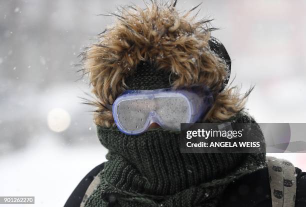 Woman wearing googles walks through the snow on January 4, 2018 in Brooklyn, New York. - A giant winter "bomb cyclone" walloped the US East Coast on...