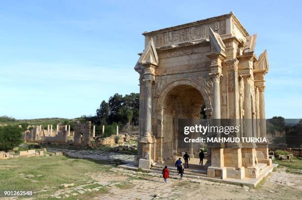 General view shows Libyans walking under the Arch of Septimius Severus at the entrance to the ruins of the ancient Roman city of Leptis Magna in...