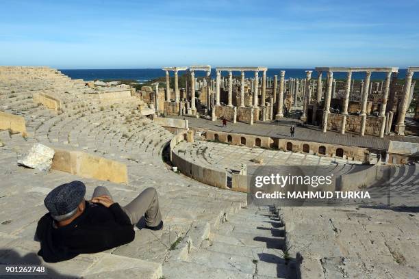 Libyan man sits in the theatre in the ruins of the ancient Roman city of Leptis Magna in al-Khums, 130 kilometres east of the Libyan capital,...