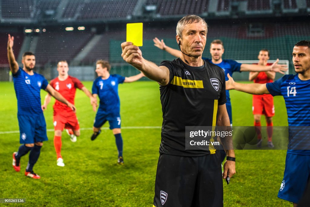 Soccer referee showing yellow card