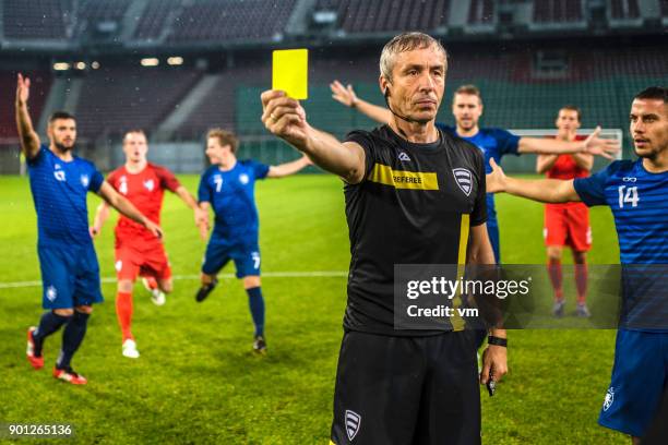 cartão de apresentando amarelo de árbitro de futebol - foul sports - fotografias e filmes do acervo