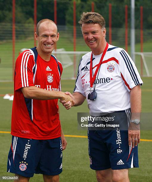 New Dutch forward Arjen Robben of FC Bayern Muenchen and FC Bayern Muenchen head coach Louis van Gaal shake hands during the Bayern Muenchen training...