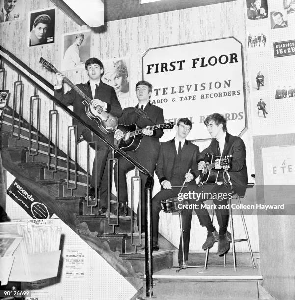 The Beatles pose on the stairs of NEMS , Brian Epstein's Liverpool record shop, having just signed a management deal with Brian, 1964.