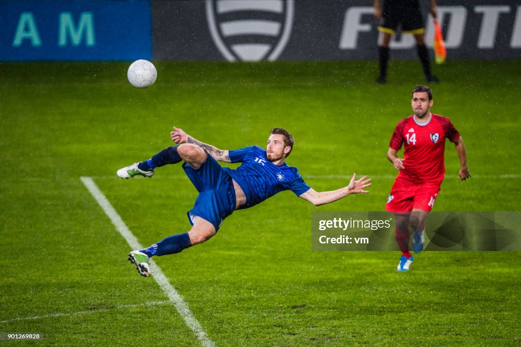 Voetbal-speler die een volley schoot uitvoeren