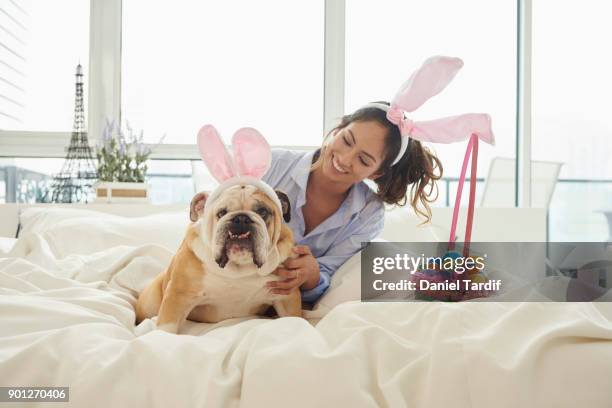 young woman on bed with dog - dog easter stock-fotos und bilder