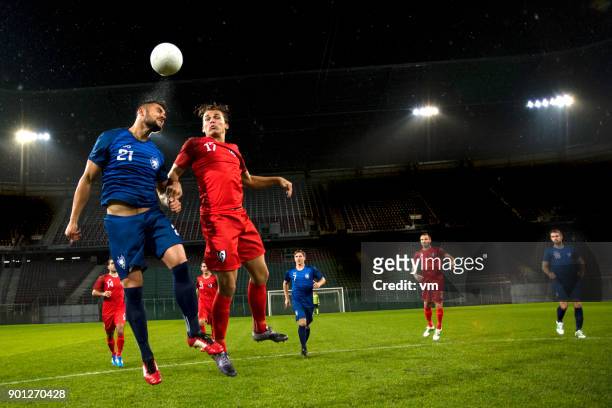 soccer player heading the ball - football player stock pictures, royalty-free photos & images