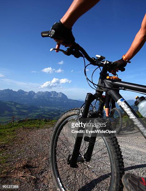 Two female mountainbiker cycling down the Hahnenkamm with a view on the Kaisergebirge on August 16, 2009 in Kitzbuhel, Austria. Kitzbuehel is famous...