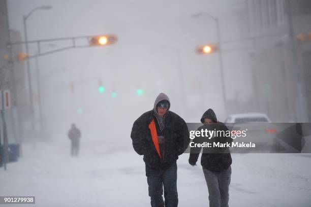 Man and woman react to the wind and snow on January 4, 2018 in Atlantic City, New Jersey. A "bomb cyclone" winter storm, has caused every East Coast...