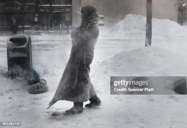 Gage, who is homeless, pauses outside of a coffee shop on the streets of Boston as snow falls from a massive winter storm on January 4, 2018 in...