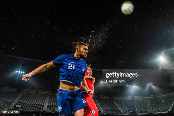 joueur de football en direction de la balle - heading the ball photos et images de collection